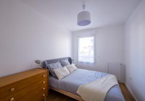 a bedroom with a bed and a dresser and a window at Sombrero - SILS in Caen