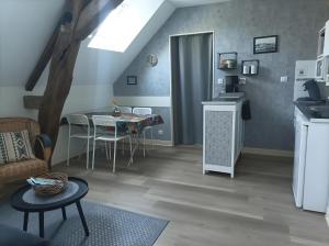 a living room with a kitchen and a dining room table at Gîte La Voilerie avec spa in Saint-Georges-sur-Cher