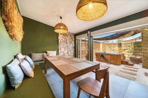ein Esszimmer mit einem Holztisch und Stühlen in der Unterkunft Villa Naroli-7pers-Jacuzzi-Plage in La Saline