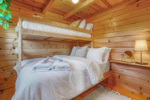 a bedroom with a bunk bed in a log cabin at Panoramic Paradise - Hot Tub in Brookville