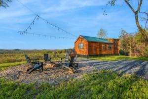 a cabin with a picnic table and benches in front of it at Panoramic Paradise - Hot Tub in Brookville