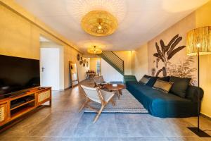 ein Wohnzimmer mit einem blauen Sofa und einem Tisch in der Unterkunft Villa Naroli-7pers-Jacuzzi-Plage in La Saline
