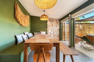 ein Esszimmer mit einem Holztisch und Stühlen in der Unterkunft Villa Naroli-7pers-Jacuzzi-Plage in La Saline
