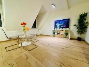 a living room with a table and a tv at The Downtown Experience - 2 BR, Bright, Spacious & Central in Brussels