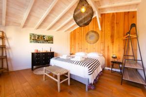 a bedroom with a white bed and wooden walls at Villa Alhena à Lège with heated swimming pool in Lège-Cap-Ferret