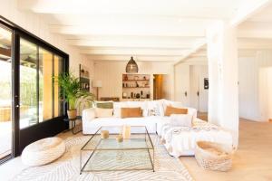a living room with a white couch and a table at Villa Alhena à Lège with heated swimming pool in Lège-Cap-Ferret