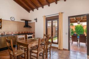 コニル・デ・ラ・フロンテーラにあるVilla Marta Claraの木製のテーブルと椅子のあるキッチンとダイニングルーム