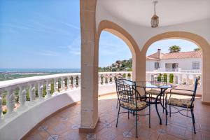 a patio with a table and chairs on a balcony at Tossal Gros in La Font D´En Carròs