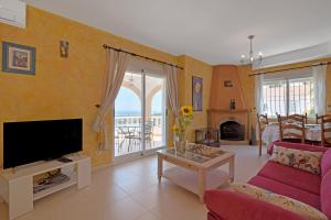 a living room with a tv and a couch and a table at Tossal Gros in La Font D´En Carròs