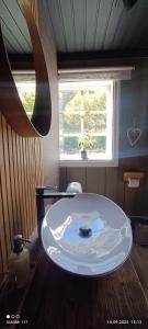 a bathroom with a white sink in front of a window at Cozy cabin in the Gilja paradise in Frafjord