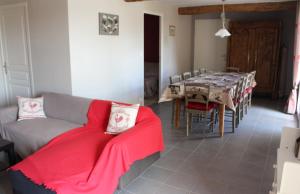 a living room with a couch and a dining table at Gîte Ti Ruz - La Cour Chevalier in Hirel