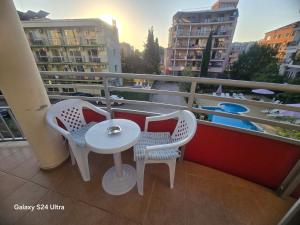 d'un balcon avec une table, des chaises et une piscine. dans l'établissement Central Plaza Apartment, à Sunny Beach