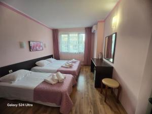 une chambre d'hôtel avec deux lits et un miroir dans l'établissement Central Plaza Apartment, à Sunny Beach 44 autres photos