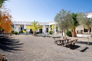 een park met banken en bomen voor een gebouw bij Finca Emblemática - Nº2 Chibusque in La Vegueta