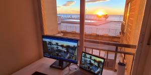 a desk with two monitors and a window with a view of the ocean at Sea View And Luxury On The Beach in Torrevieja