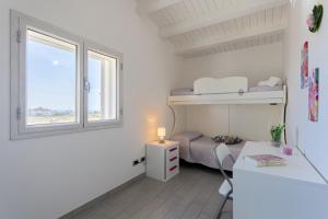 a room with a bed and a desk and a window at Torre del mare in Menfi +36 photos