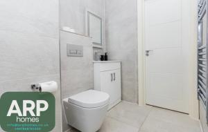 BuckinghamshireにあるElegant Central, Private Parking, Leisure, Contractorのトイレと鏡のある白いバスルーム