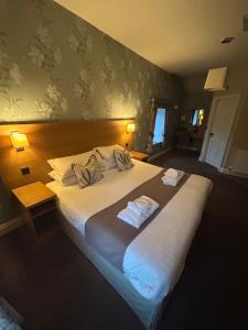 a bedroom with a large bed with two towels on it at The Black Lion in Llanfair Talhaiarn