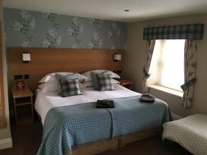 a bedroom with a large bed with a blue blanket at The Black Lion in Llanfair Talhaiarn