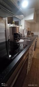 a kitchen with a black counter top with a microwave at Cozy cabin in the Gilja paradise in Frafjord