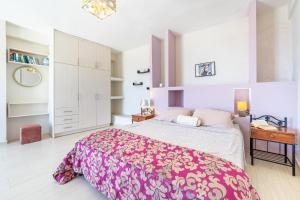 a bedroom with a large bed with a pink bedspread at Studio Salvia in Katávolos