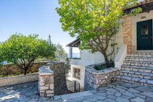 a house with a green door and stairs at Studio Salvia in Katávolos