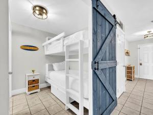 ein Schlafzimmer mit Etagenbetten und einer Schiebetür im Scheunenstil in der Unterkunft Laketown Wharf 1213 in Panama City Beach + 53 Fotos