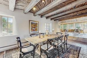 een eetkamer met een houten tafel en stoelen bij Historic Hacienda in Ranchos de Taos