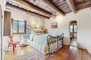 een slaapkamer met een bed en een houten plafond bij Historic Hacienda in Ranchos de Taos
