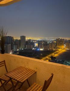 2 krzesła i stół na balkonie z panoramą miasta w obiekcie Mens Private room with washroom and balcony w Szardży