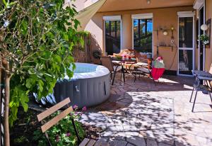 a patio with a hot tub and a table and chairs at Art Styles Boutique Apartment Szentendre in Szentendre