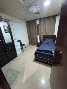 sypialnia z łóżkiem i krzesłem w obiekcie Mens Private room with washroom and balcony w Szardży