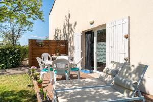 un patio avec une table et des chaises sur un patio dans l'établissement Les Demeures du Ventoux, à Aubignan