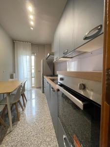 a kitchen with white cabinets and a wooden table at Dimora Vibo Centro in Vibo Valentia