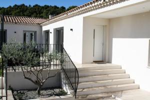 a white house with stairs and a tree at La Villa Haute - Maison De Vacances in Mormoiron