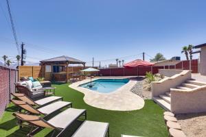 a backyard with chairs and a swimming pool and a house at 2 Mi to Lake Havasu Home with Patio and Pool in Lake Havasu City