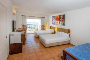 una habitación de hotel con dos camas y un escritorio en Royal Decameron Salinitas - All Inclusive, en Los Cóbanos