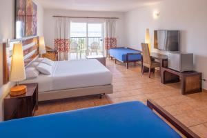 Una habitación de hotel con un dormitorio con una cama y un escritorio. en Royal Decameron Salinitas - All Inclusive, en Los Cóbanos
