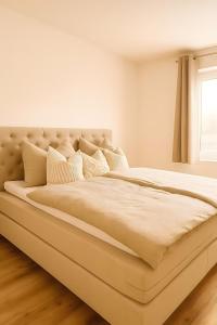 a large bed in a white room with a window at Ferienwohnung Pruggernglück in Pruggern