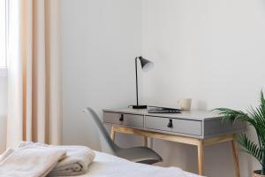 a desk in a bedroom with a bed and a chair at Le Cocon des Allamandières in Chonas-lʼAmballan