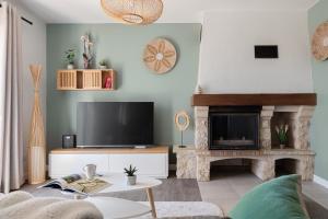 a living room with a tv and a fireplace at Le Cocon des Allamandières in Chonas-lʼAmballan