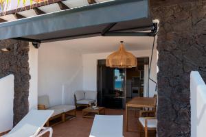 a living room with a table and chairs and a chandelier at Gold View in Costa Calma