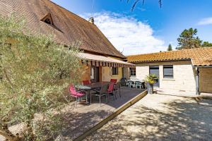 eine Terrasse mit Tisch und Stühlen und ein Gebäude in der Unterkunft La Trappe in Sarlat-la-Canéda