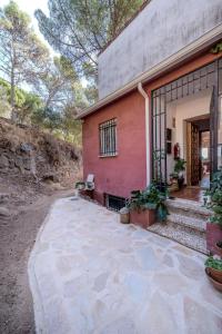 a pink house with a stone walkway in front of it at Chalet en la naturaleza a 1 hora de Madrid y WIFI in San Martín de Valdeiglesias