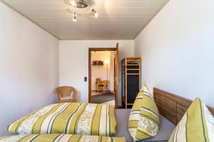 una camera da letto con un letto con cuscini gialli e verdi di Raus Aufs Land a Schmallenberg