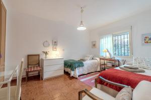 a bedroom with two beds and a living room at Chalet en la naturaleza a 1 hora de Madrid y WIFI in San Martín de Valdeiglesias