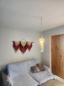a room with a bed with curtains and a chandelier at Casa Vista Mar - Iemanjá in Itacaré