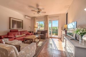 a living room with a red couch and a tv at Chalet en la naturaleza a 1 hora de Madrid y WIFI in San Martín de Valdeiglesias