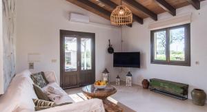 a living room with a couch and a tv at Finca Sa Real in Cala Millor