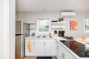 una cucina bianca con lavello e frigorifero di 3mi to Downtown Hot Tub Fire Pit a Garner Altre 11 foto